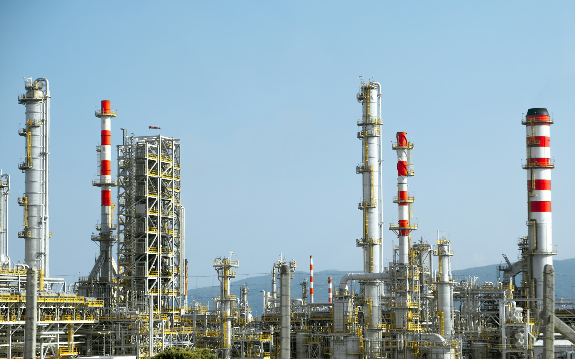 A large industrial plant with red and white smokestacks.