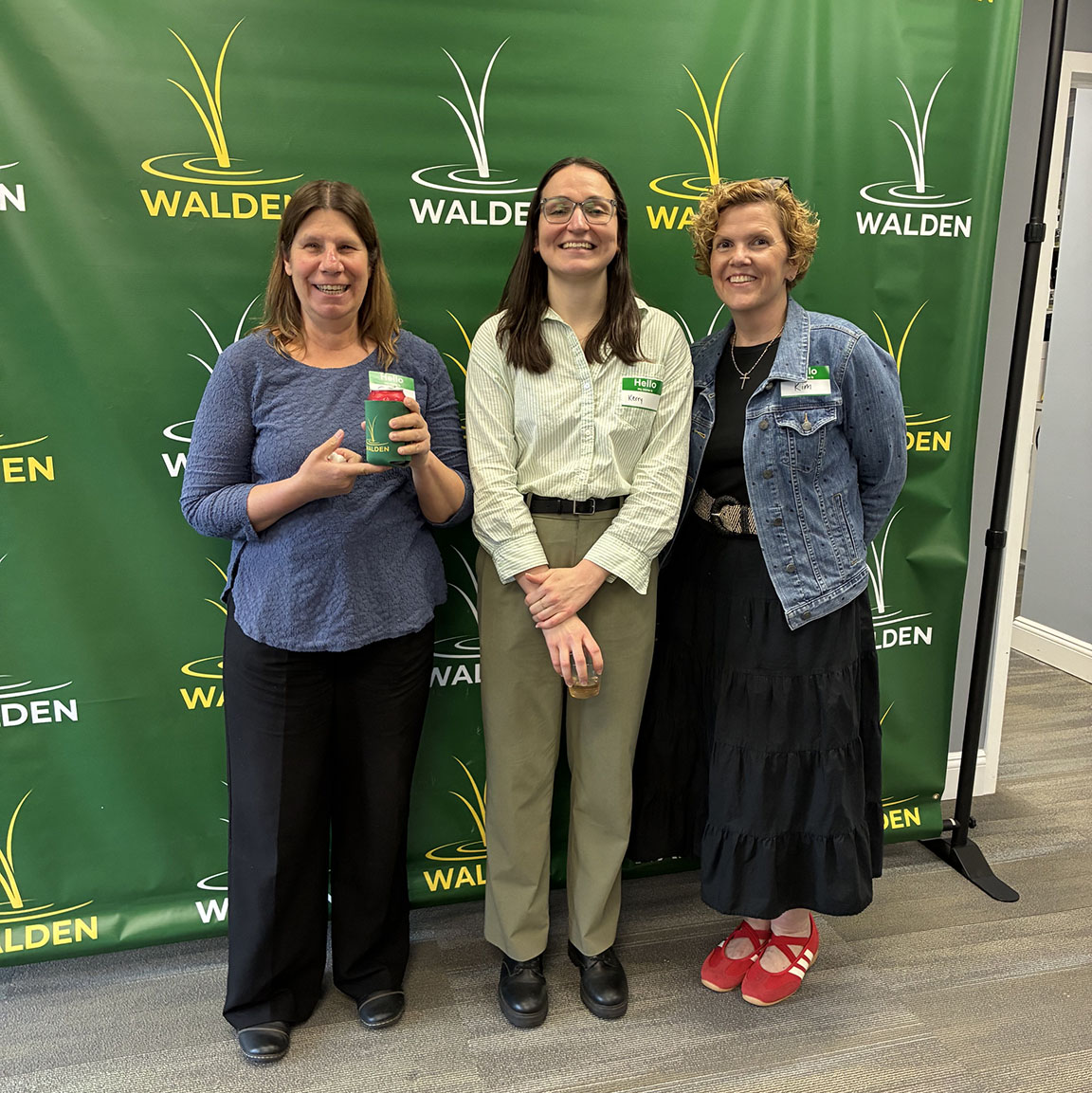 three women stand in front of a green backdrop