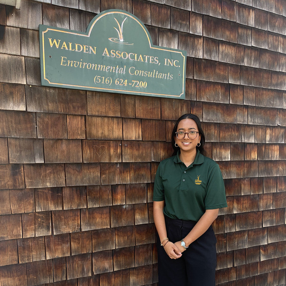 A college student standing in front of an office building.