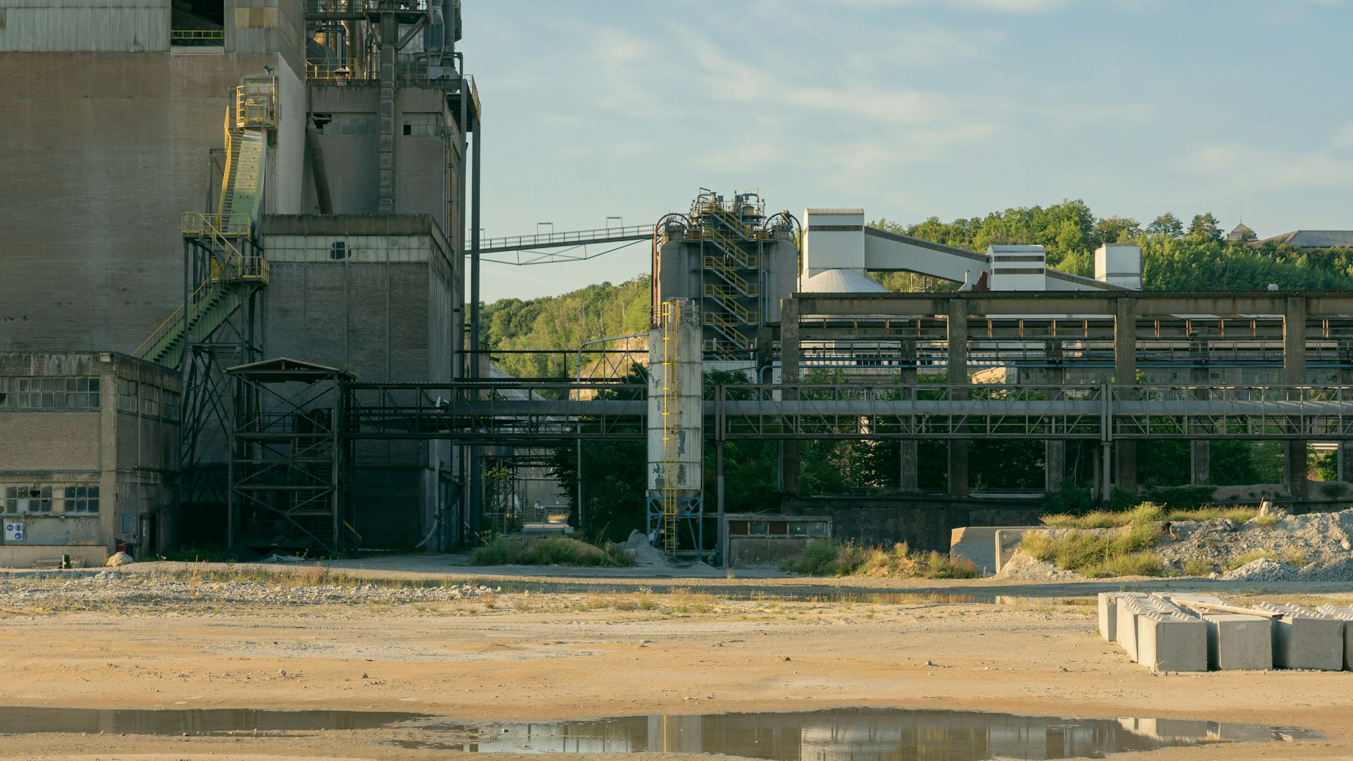 An industrial plant with a dirt field in the foreground.