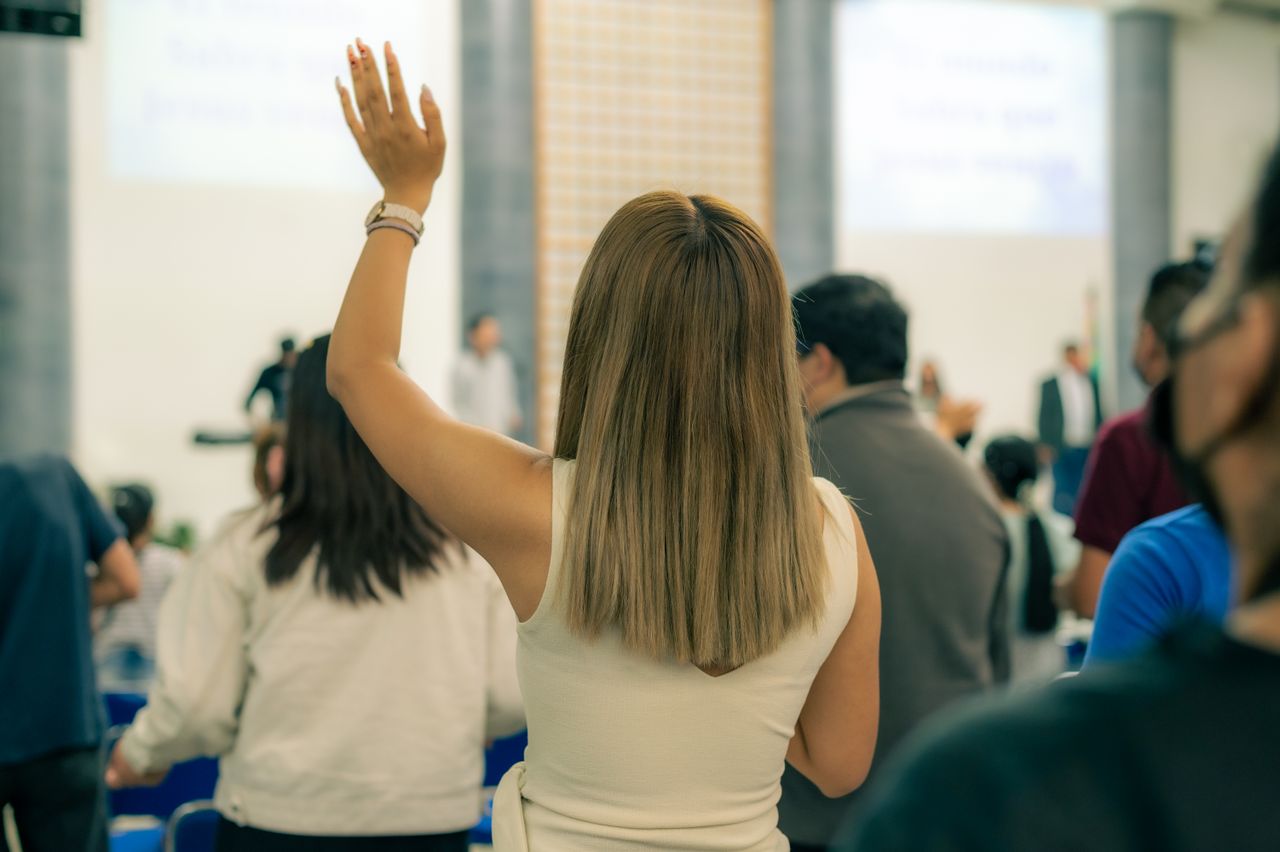 a woman raising her hand in a meeting